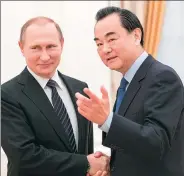  ?? WU ZHUANG / XINHUA ?? Russian President Vladimir Putin greets Foreign Minister Wang Yi during a meeting at the Kremlin in Moscow on Thursday.