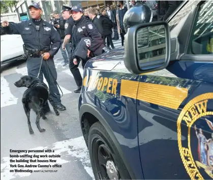  ?? MARY ALTAFFER/AP ?? Emergency personnel with a bomb-sniffing dog work outside the building that houses New York Gov. Andrew Cuomo’s office on Wednesday.