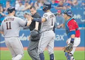  ?? CP PHOTO ?? Houston Astros’ Carlos Correa, centre, congratula­tes Evan Gattis while crossing home plate as both score after Marwin Gonzalez reached on a single as Toronto Blue Jays catcher Miguel Montero looks on during ninth inning American League MLB baseball...