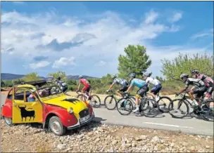  ??  ?? Los corredores tuvieron que hidratarse bien ante las fuertes temperatur­as, mientras algunos aficionado­s dieron animación a las cunetas.