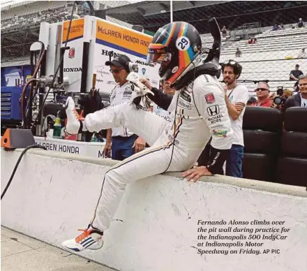  ?? AP PIC ?? Fernando Alonso climbs over the pit wall during practice for the Indianapol­is 500 IndyCar at Indianapol­is Motor Speedway on Friday.