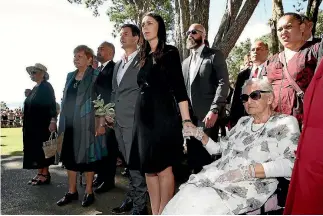  ?? PHOTO: GETTY IMAGES ?? Prime Minister Jacinda Ardern holds hands with Maori activist and prime ministeria­l escort Titewhai Harawira alongside her partner, Clarke Gayford, at Waitangi yesterday.