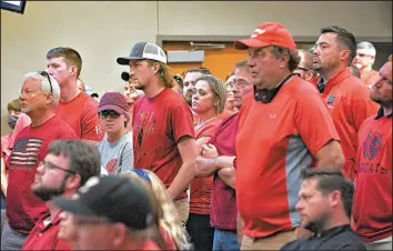  ?? ERIN BORMETT/THE ARGUS LEADER ?? People wear red in solidarity against a citywide mask mandate during a city council meeting Sept. 2 in Brookings, South Dakota. COVID-19 infections are on the rise in the Dakotas.