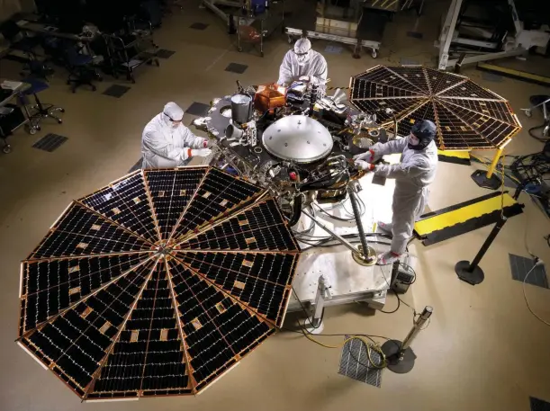  ??  ?? ABOVE: In a clean room, the solar array on InSight is deployed for testingRIG­HT: Assembling the SEIS instrument for measuring Marsquakes