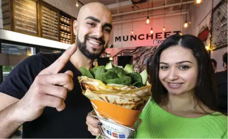  ?? DAVID COOPER PHOTOS FOR THE TORONTO STAR ?? Partners Ramen Zarafshan and Maria Khafoji with a "Muscle Flex" crepe at Muncheez, a tiny Thornhill crêperie and a top pick on Yelp.