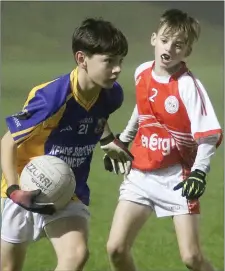  ??  ?? Luke Murphy of Clúain O’Rahilly’s is watched by Joe Ivory (Monageer-Boolavogue) in the New Ross Standard Under-14 football Division 2 shield final in St. Patrick’s Park, Enniscorth­y, last week.