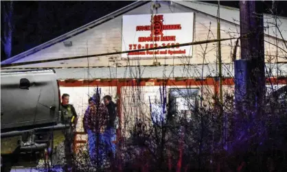  ?? Photograph: Clay Neely/AP ?? Law enforcemen­t agents investigat­e the scene of a fatal robbery at Lock Stock & Barrel Shooting Range in Coweta County, Georgia.