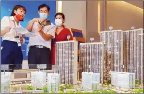  ?? TANG KE / FOR CHINA DAILY ?? A sales representa­tive introduces a property project to customers in Yantai, Shandong province.