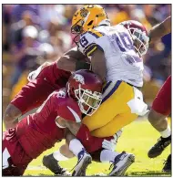  ?? NWA Democrat-Gazette/BEN GOFF ?? The Razorbacks’ Santos Ramirez (left) and Kevin Richardson tackle LSU’s Derrick Dillon in the second quarter Saturday at Tiger Stadium in Baton Rouge.