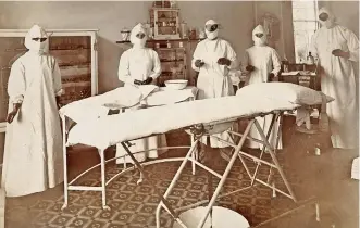  ??  ?? Fotografía de 1909 de médicos en la sala de operacione­s del hospital Wotton Lodge, Gloucester, Inglaterra. Se observa que están cubiertos casi totalmente de la cabeza, al igual que la bata, misma que parece un camisón.