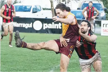  ??  ?? Drouin backman Brendan Dower gets his kick away, beating the late tackling attempt by Maffra captain Dan Bedggood, to relieve some pressure in Saturday’s senior match.