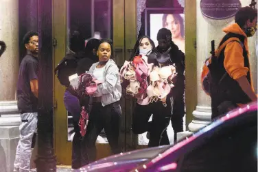  ?? Noah Berger / Associated Press ?? Women carry merchandis­e from a Union Square Victoria's Secret store in San Francisco on May 30. Police say many of the smashandgr­ab thefts have been carried out by caravans of wellcoordi­nated criminals.