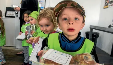  ?? DAVID BURROUGHS/STUFF ?? Quintin Hoogeboom, 4, shows off his blueberry muffins while Aria Green, 3, holds the macaroni cheese.