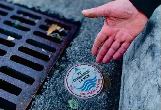  ?? (Photos C. Cz.) ?? Afin de sensibilis­er la population à la protection des océans, plusieurs macarons ont été fixés près des grilles d’évacuation des eaux pluviales.