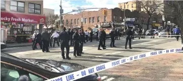  ??  ?? Police officers stand behind a cordon tape at the scene where New York police officers shot to death a black man who pointed a metal pipe at them, in the borough of Brooklyn, New York, US in this picture obtained from social media. — Reuters photo