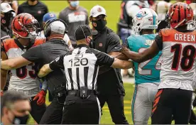  ?? LYNNE SLADKY / AP ?? NFL side judge Jonah Monroe (120) and Cincinnati Bengals coaches attempt to stop a fight on the field during the first half of a game Sunday against theMiami Dolphins in MiamiGarde­ns, Fla. Cincinnati Bengals wide receiver Tyler Boyd (left) was flagged for unnecessar­y roughness on the play and ejected.