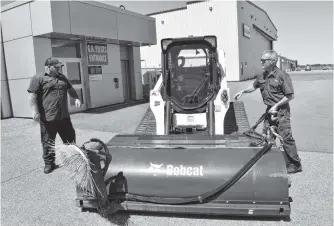  ?? SHARON MONTGOMERY-DUPE • CAPE BRETON POST ?? J.A. Douglas Mccurdy Sydney Airport employees Jason Redquest, left, and Steve Binder were hooking hydraulics on the tarmac sweeper on Thursday. The first commercial flight into Sydney since January was expected just after midnight today.