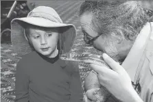  ??  ?? Paul Kennedy of Little Ray’s Reptile Zoo shows four-year-old Gavin Mills a coastal carpet python in Sudbury earlier this month. .