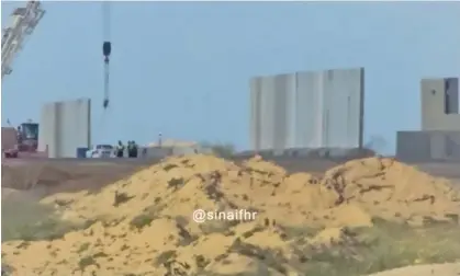  ?? ?? A screenshot of the video from Sinai for Human Rights shows a wall being built on the Egyptian side of Rafah. Photograph: @Sinaifhr