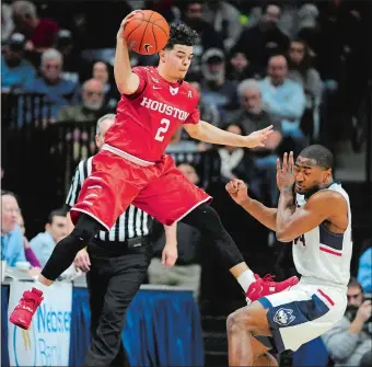  ?? JESSICA HILL/AP PHOTO ?? UConn’s Rodney Purvis, right, ducks as Houston’s Rob Gray, Jr., attempts to save the ball from going out of bounds during Sunday’s game in Storrs. Houston beat the Huskies 75-68.