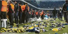  ?? Foto: Muhammed Enes Yildirim/Anadolu, Getty Images ?? Fußballfan­s von Fenerbahce Istanbul werfen Schals und Mützen aufs Spielfeld. Diese sollen den Opfern zugutekomm­en.