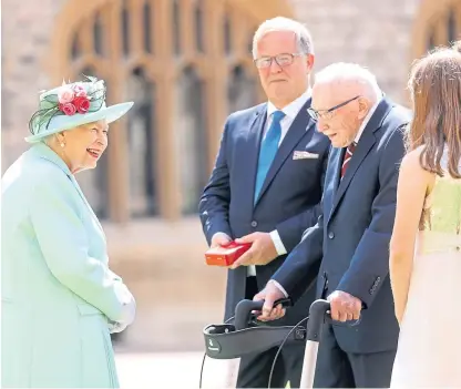  ??  ?? The Queen talks to Captain Sir Tom Moore and his family after she had knighted him at Windsor.