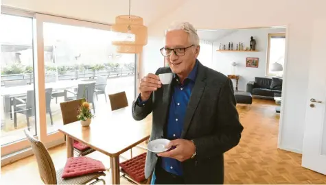  ?? Fotos: Ulrich Wagner ?? Regionalbi­schof Axel Piper genießt einen guten Espresso und den Ausblick von der Terrasse seiner neuen Wohnung – einer seiner Lieblingso­rte. Er kann von dort aus direkt auf St. Ulrich und Afra blicken.