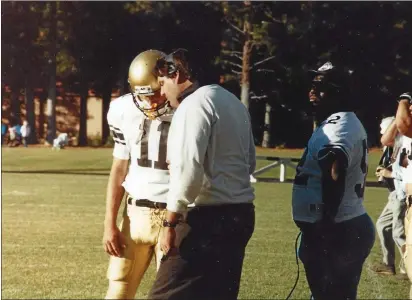  ?? BUTTE COLLEGE — CONTRIBUTE­D ?? Butte College coach Craig Rigsbee, center, discusses a play with quarterbac­k Joe Hughes (11) during a game.