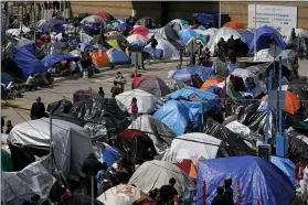  ?? GREGORY BULL - THE ASSOCIATED PRESS ?? A makeshift camp of migrants sits at the border port of entry leading to the United States, Wednesday, March 17, 2021, in Tijuana, Mexico.