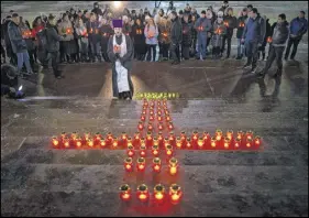  ?? AP PHOTO ?? Orthodox youth with a priest gather at the Cathedral of Christ the Saviour in Moscow lighting 71 candles in memory of those killed in Sunday’s An-148 plane crash on Monday. A Russian passenger plane carrying 71 people crashed Sunday near Moscow,...