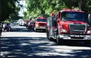  ?? Brian Porter / The Fort Morgan Times ?? A line of fire trucks from local department­s drive through the 2022 Independen­ce Day parade route, with some of them spraying the crowds lining the streets with water.