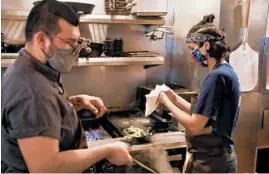  ?? CHRIS SWEDA/CHICAGO TRIBUNE ?? Line cooks Juan Espinal, left, and Amy Collazo work in the kitchen Tuesday, at Avec West Loop in Chicago.