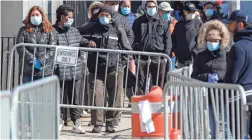  ?? JOHN MINCHILLO/AP ?? Patients wearing face masks and personal protective equipment wait for virus testing outside Elmhurst Hospital Center in New York City.