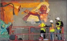  ?? SARAH REINGEWIRT­Z — STAFF PHOTOGRAPH­ER ?? The mural “Hitting the Wall,” by artist Judy Baca, which was painted over by a graffiti abatement contractor, is being unveiled again as a Social and Public Art Resource Center crew power-washes the nearly 10coats of paint covering the mural along the 110 Freeway in Los Angeles on June 25.