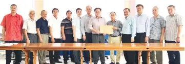  ??  ?? SUCCC Supervisor­y Committee chairman cum Beaufort Chinese Chamber of Commerce president, Datuk Seri Panglima Chong Nyuk Yong (fifth right), handing over a document containing the list of member chambers who support Liew (eighth from left) to lead the associatio­n while the leaders of the member chambers look on.