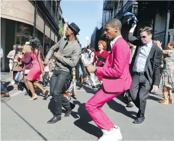  ??  ?? Aloe Blacc, centre left, and and Jon Batiste, centre right, march along with a celebrator­y crowd during a parade through New Orleans in America’s Musical Journey.