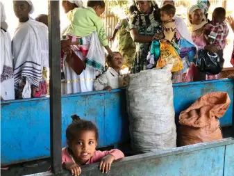  ??  ?? LEFT: A typical street populated by members of Gondar’s Jewish community. A TODDLER smiles; she has been included in a special nutrition program providing malnourish­ed children under the age of five with a simple meal every morning.