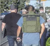  ?? Austin Dave/The Signal ?? The Los Angeles County Sheriff’s Department Human Traffickin­g Task Force prepares to enter a massage parlor on the 18400 block of Soledad Canyon Road in September.