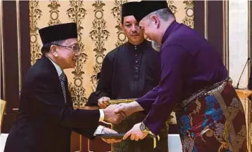  ??  ?? SULTAN Muhammad V mengurniak­an Surat Cara Pelantikan Ketua Hakim Negara kepada Malanjum di Istana Negara, malam tadi.