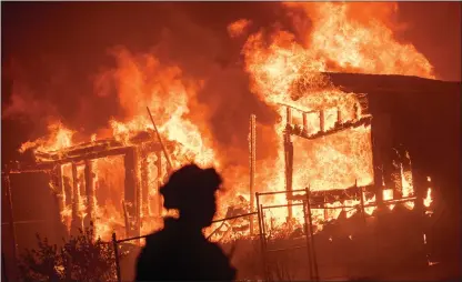  ?? The Associated Press ?? Evening winds drove the fire through several neighborho­ods leveling homes in its path.