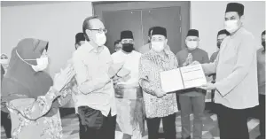  ??  ?? TAHNIAH: Jaffari (kanan) menyerahka­n borang keahlian kepada Hajiji sambil diperhatik­an oleh Masidi (dua kiri) dan pemimpin BERSATU Sabah.