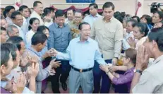  ?? — AFP ?? Cambodia’s Prime Minister Hun Sen (C) greets commune councillor­s at a polling station in Kandal province on Sunday.