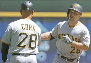  ?? (Photo by Aaron Gash, AP) ?? Former Mississipp­i State player Adam Frazier (26) of the Pittsburgh Pirates is congratula­ted by Joey Cora after hitting a home run during the first inning of Sunday’s game against the Milwaukee Brewers.