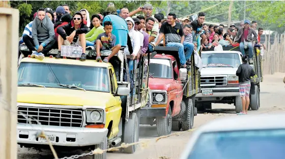  ?? FOTOS HéCTOR PALACIO ?? Tres camiones atestados de venezolano­s ingresan de manera ilegal por la trocha ‘la Cortica’, una de las 180 trochas que comunican a Colombia y Venezuela.