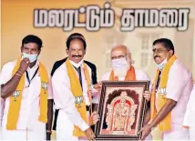  ??  ?? Prime Minister Narendra Modi being presented a memento by Puducherry party leaders during a public meeting in the UT on Thursday