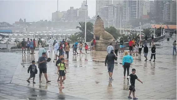  ?? GABRIEL BULACIO ?? Gris y lluvia. La jornada de ayer no se presentó para ir a la playa y muchos turistas eligieron pasear por La Rambla.