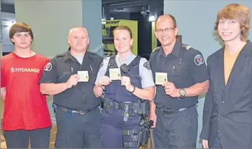  ?? Booster photo by Jason Kerr ?? Swift Current EMS representa­tives Duane Doan and Nelson Pompu are shown with RCMP Const. Jennifer Lepage in showcasing the Swift Current Drug Task Force’s Positive Ticket Campaign along with Youth Leadership Award Winners Dylan Griffin and Shelby...