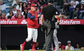  ?? ASHLEY LANDIS / AP ?? Los Angeles Angels’ manager Joe Maddon, left, disputes a stolen base call during the fifth inning of a baseball game against the Boston Red Sox in Anaheim, Calif. on Monday.