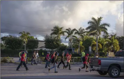  ?? KIRSTEN LUCE — THE NEW YORK TIMES ?? Day laborers, including some migrant children, gather on a school day to find roofing, landscapin­g or other work, in Homestead, Fla., in August. Migrant children arriving to the U. S. in record numbers are ending up in dangerous jobs that violate child labor laws — including in factories that make some of the country’s bestknown products.