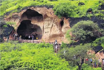  ?? Pictures Ahmed Jadallah / Reuters ?? Tourists walk to and from a cave at Ain Razat, a spring in Salalah in Dhofar province, Oman, this month.